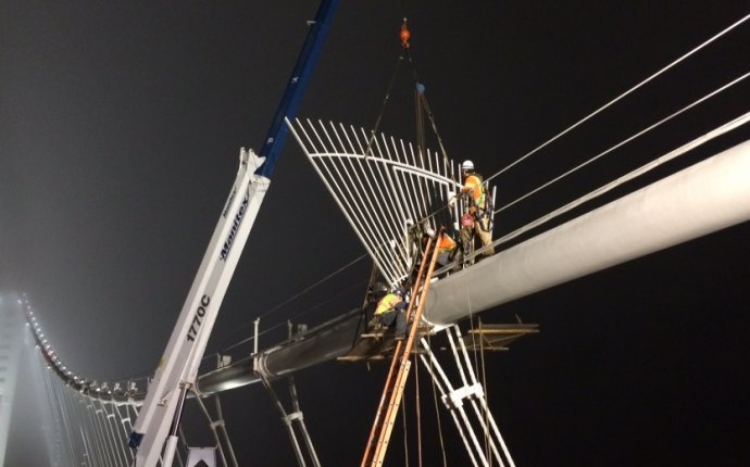 Crews installing gates on the main cable of the self-anchored