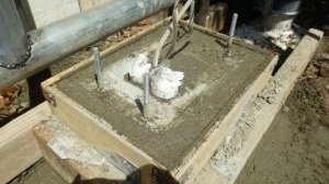 Concrete mix is still wet. Note the mounting bracket is placed on top of the mix with the four anchor bolts buried inside.